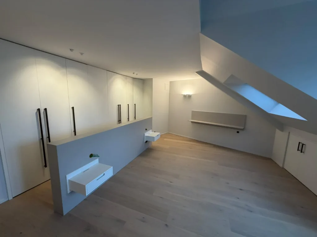 Suite sous combles avec penderies intégrées, cloison basse et parquet bois clair