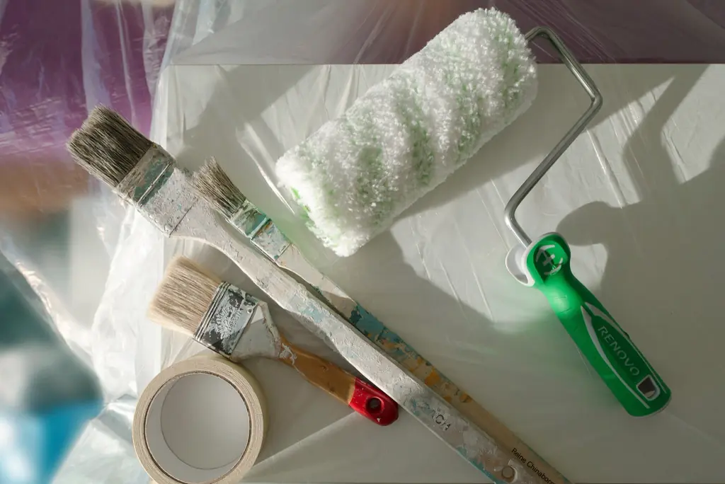 Rouleau, pinceaux et ruban de masquage prêts pour des travaux de peinture