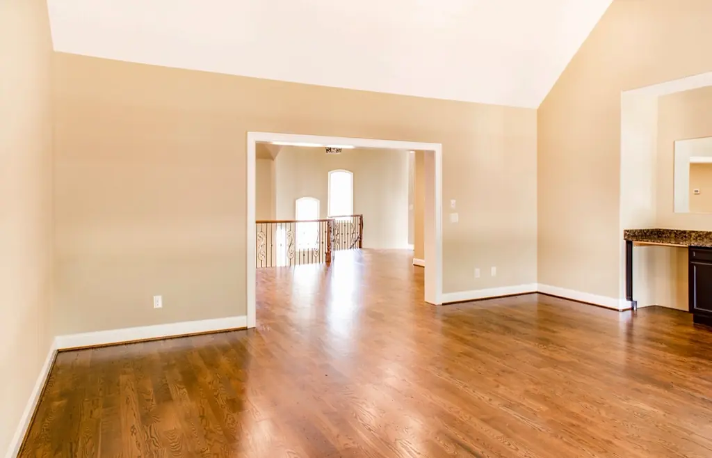 Pièce vide au parquet clair et aux murs fraîchement peints