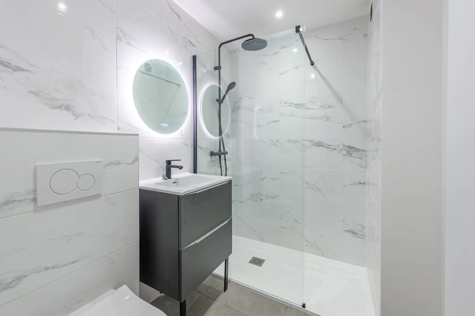 Salle d’eau à la faïence effet marbre, douche vitrée et meuble vasque suspendu